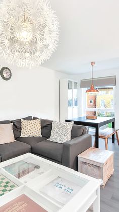 a living room filled with furniture and a large white chandelier