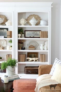 a living room filled with furniture and bookshelves covered in white bookcases