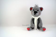 a crocheted koala bear with red eyes and a white scarf around it's neck