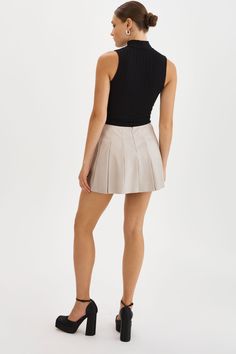 The Juliana Pleated Skirt is effortlessly feminine with its playful pleats and mini length. Pair it with sneakers and an oversized sweater for a casual look, or dress it up with knee-high boots for an evening ensemble.