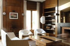 a living room with two white chairs and a fire place in the middle of it