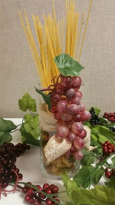 grapes and other fruits are arranged in a vase