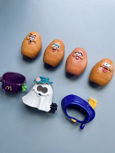 five rocks with faces painted on them sitting next to a toothbrush and other toys