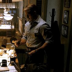 a man standing in front of a kitchen counter with food on the counter and utensils hanging from the ceiling