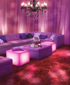 a living room filled with purple furniture and chandelier