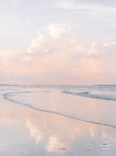 two people walking on the beach with their surfboards