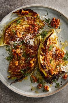 an artichoke dish with nuts and parmesan cheese on a white plate