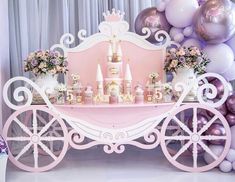 there is a pink carriage with princess decorations on it and balloons in the back ground