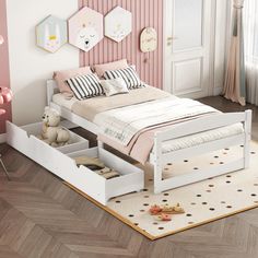 a child's bedroom with pink walls and white bed frame, drawers under the bed