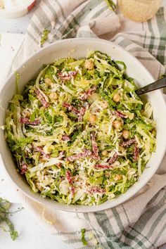 a white bowl filled with coleslaw and garnished with nuts