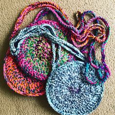 several crocheted bags are sitting on the floor