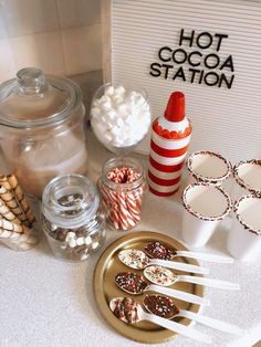 a table topped with lots of candy and candies next to a hot cocoa station sign