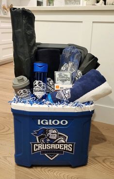 a cooler filled with sports items on top of a hard wood floor