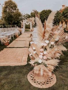 an outdoor ceremony with white flowers and pamodia in vases on the grass