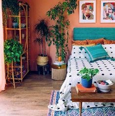 a bed room with a neatly made bed and potted plants