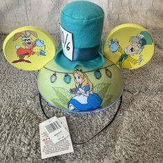 Add A Touch Of Whimsy To Your Disney Parks Ensemble With This Green Alice In Wonderland Mad Hatter Tea Party Ear Hat. Featuring Multicolored Graphics, This Unisex Hat Is Suitable For Adult Sizes 55cm And Above. Perfect For Any Disney Fan, This Hat Is A Great Addition To Your Collection Of Disneyana. Whether You're A Fan Of The Beloved Character Or Simply Love The Iconic Design, This Hat Is Sure To Make A Statement. Mickey Ear Hat, Alice In Wonderland Mad Hatter, Wonderland Mad Hatter, Ear Hat, Mad Hatter Tea, Mad Hatter Tea Party, Disney Ears, Disney Fan, Ear Hats