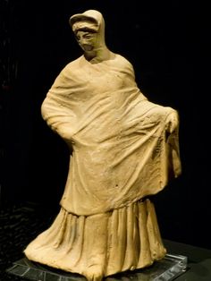 a statue of a woman wearing a white dress and holding a shawl in her hands