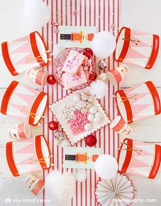 Holiday Christmas Family Table top view with Six My Mind's Eye Nutcracker Drum Shaped Plates, Nutcracker Napkins and Nutcracker Soldier Cups, sweets, cookies, ornaments, balloons and paper fan as center piece in the middle of the table over the Believe Christmas Red Striped Table Runner. These Morden and high quality party supplies with cute design in pink and red tone are so unique and adorable for holiday family gathering with kids and friends. Holiday partyware, party supplies at momoparty.com Nutcracker Themed Party, Nutcracker Drum, Nutcracker Ballet Party, Nutcracker Christmas Party, Festive Tablescape, Ballet Party, Christmas Party Themes, Kids Christmas Party, Christmas Party Supplies