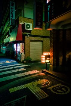 an empty street at night with the lights on and signs lit up in chinese characters