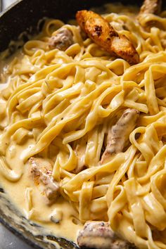 a skillet filled with pasta and chicken