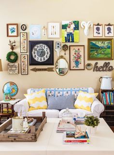 a living room filled with furniture and lots of framed pictures on the wall above it