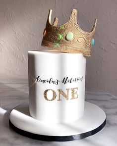 a white coffee cup with a gold crown on top