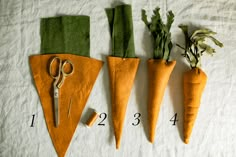 four carrots are laid out on a sheet with scissors and thread to make them look like they have been cut in half