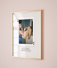 a photo frame hanging on the wall with a woman kissing a man's cheek