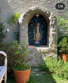 an outdoor shrine with a statue and potted plants