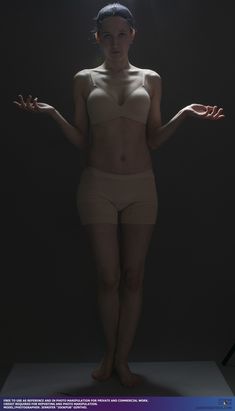 a naked woman with her hands out in front of the camera, standing on a white surface