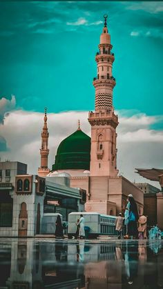 people are walking around in front of a tall building with a green dome on top