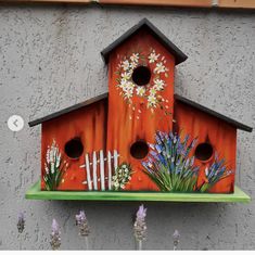 a birdhouse with flowers painted on it's side