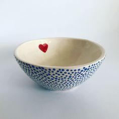 a blue and white bowl with a red heart on it