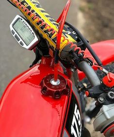 a close up view of the handlebars on a red motorbike with a speedometer