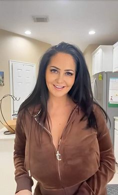 a woman standing in a kitchen holding a knife