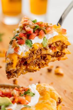 a piece of taco casserole with sour cream and toppings on top