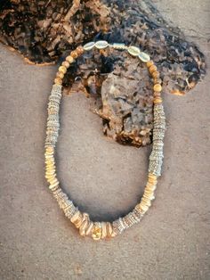 a beaded necklace sitting on top of a rock