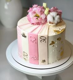 a cake decorated with books and flowers on a plate