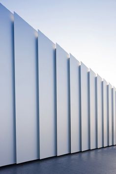 a tall white wall next to a parking meter