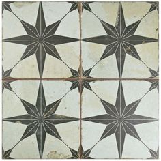 an old black and white tiled floor with star designs