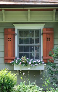 a window with wooden shutters and flower boxes