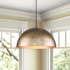 a light fixture hanging from the ceiling in a room with large windows and white walls