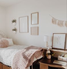 a bedroom with a bed, desk and pictures on the wall