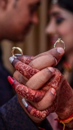 the bride and groom are holding their wedding rings