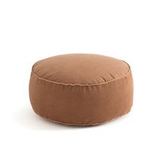 a brown round pillow sitting on top of a white floor