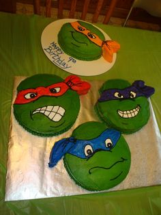 three teenaged ninja turtles are on top of each other's heads, and the cake is decorated with green frosting