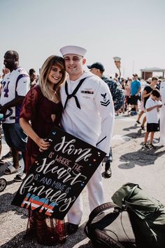 a man and woman pose for a photo while holding a sign that says, sorry to those who have served the navy