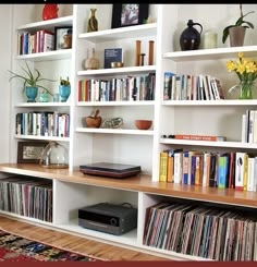 a bookshelf filled with lots of different types of books and dvds on top of it