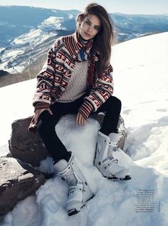 a woman sitting on top of a pile of snow