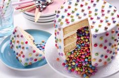 a cake with sprinkles on it sitting on a table next to plates